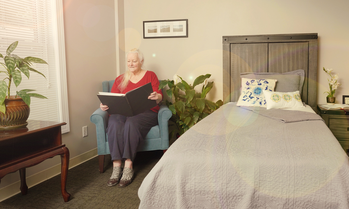 Older woman reading in her room